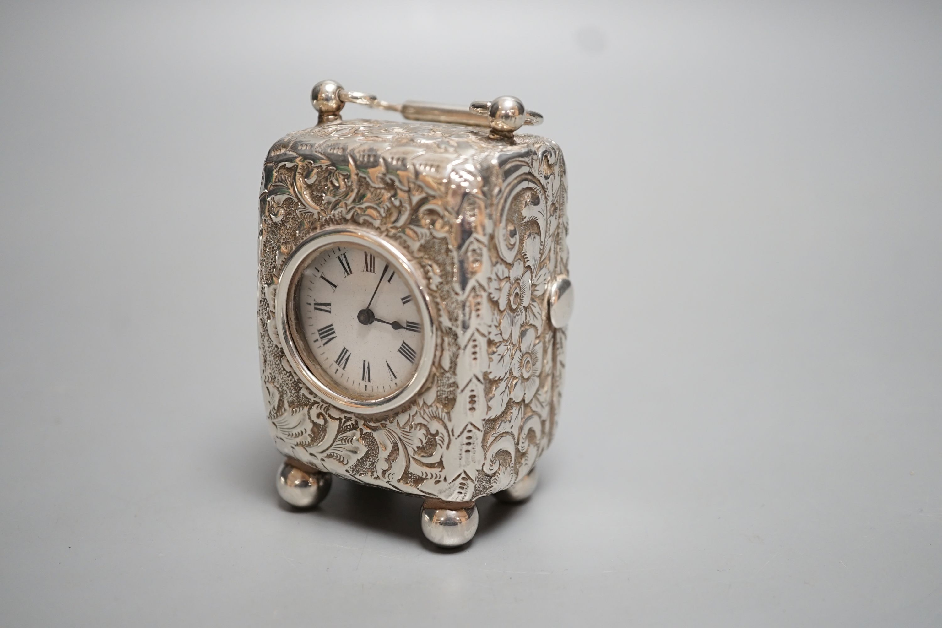 A late Victorian embossed silver cased miniature carriage timepiece, maker G.B, London, 1894, on bun feet, height 78mm.